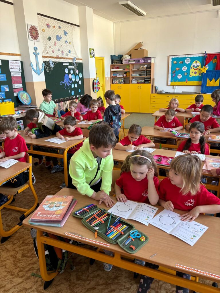 děti sedí v lavících na návštěvě ZŠ